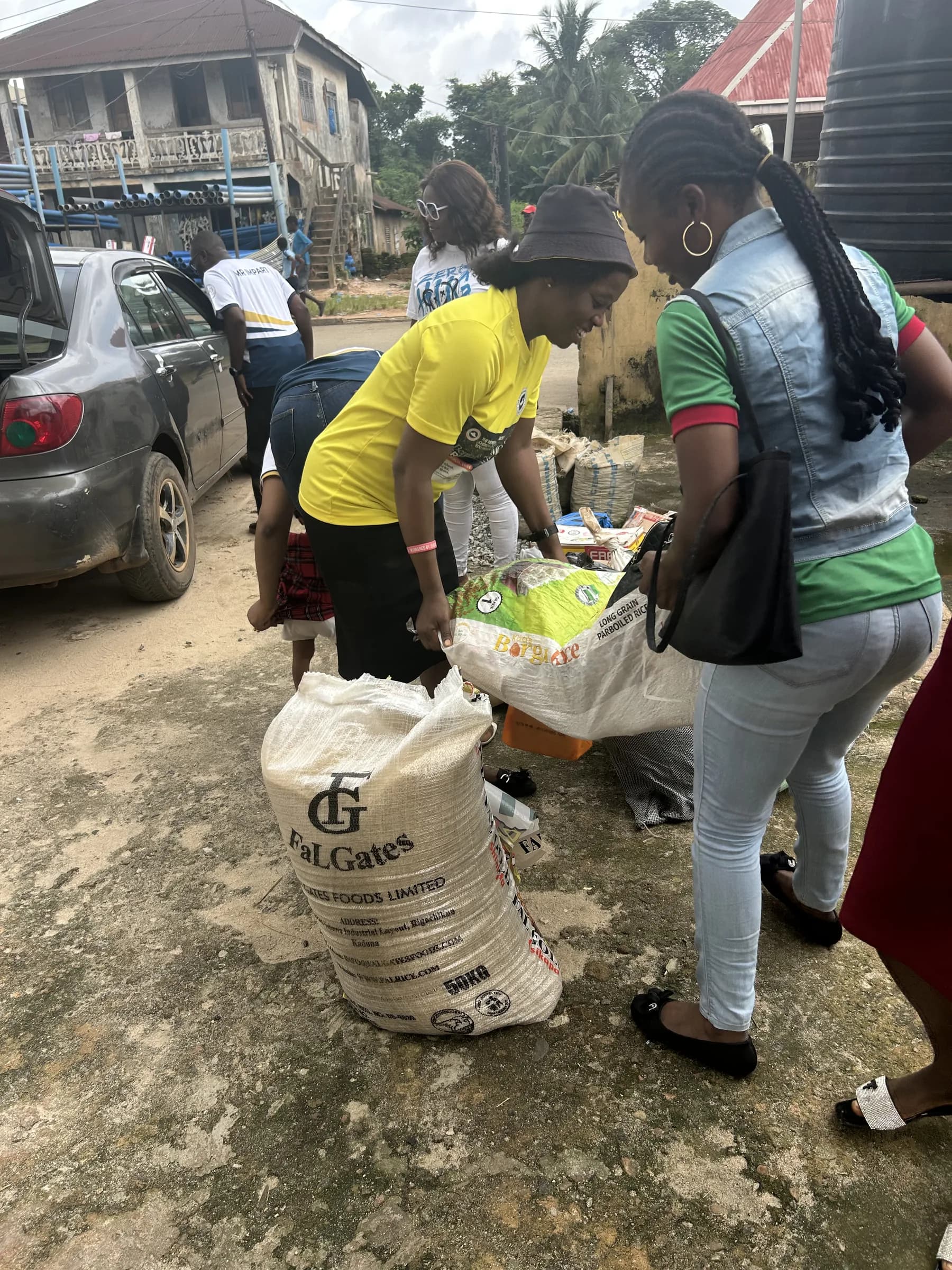 Volunteers unloading sacks of donated supplies from a vehicle.