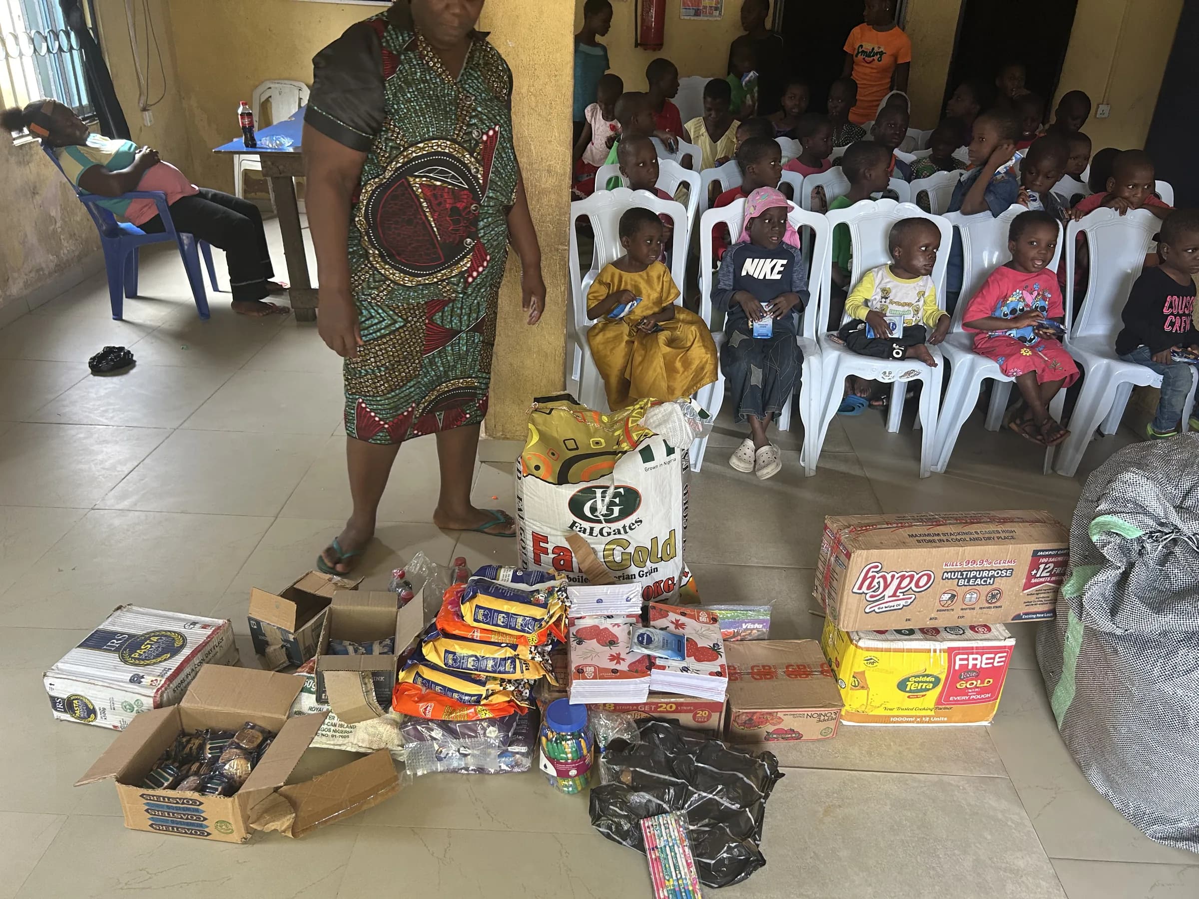 Bags and boxes of donated food, clothing and household items laid out for distribution.
