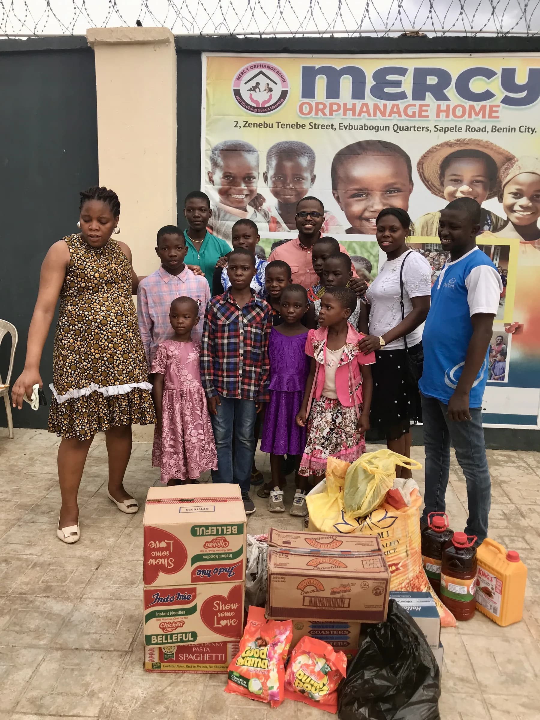 Donated food and household supplies stacked ready for distribution at an orphanage.
