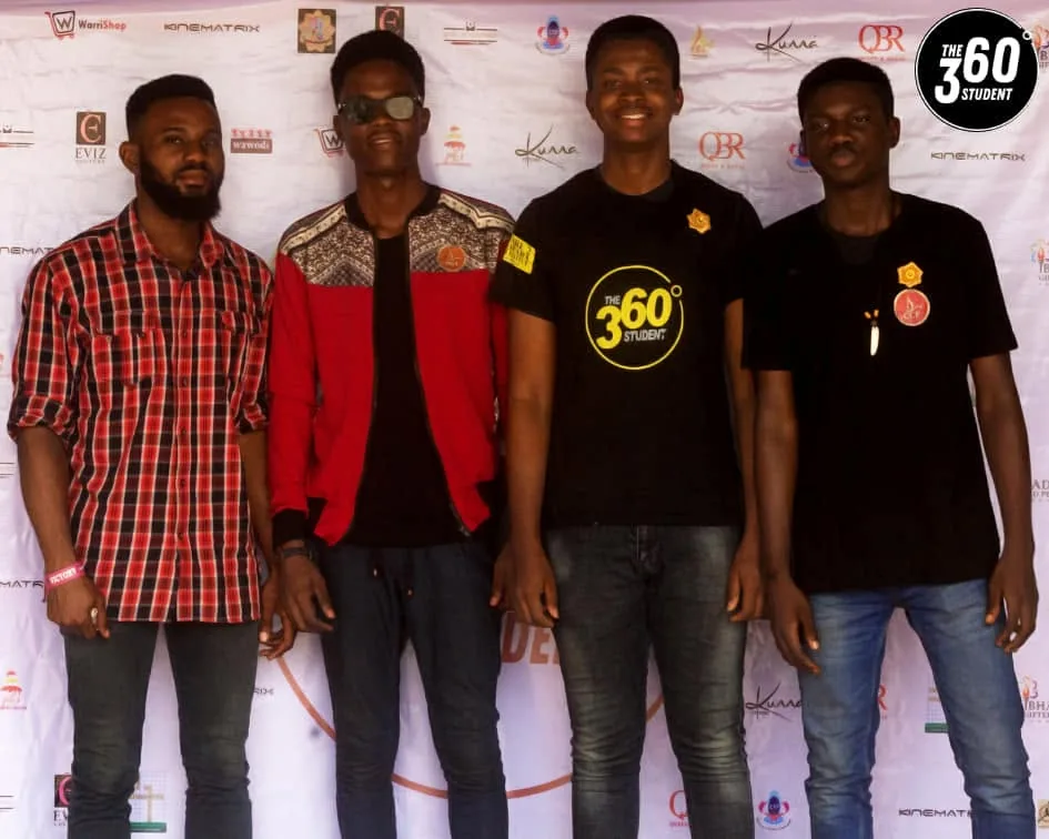 Volunteers in branded shirts standing together at the event backdrop.