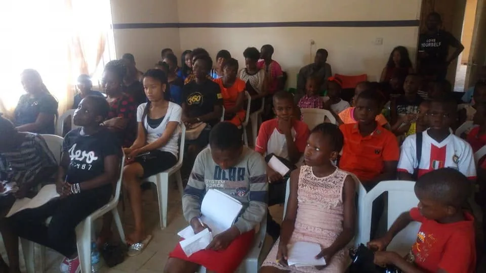 Young people seated in rows during a club session.