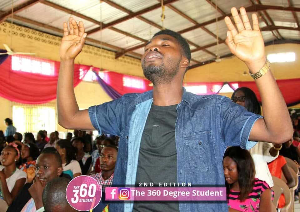 A delegate with both hands raised during a session at the conference.