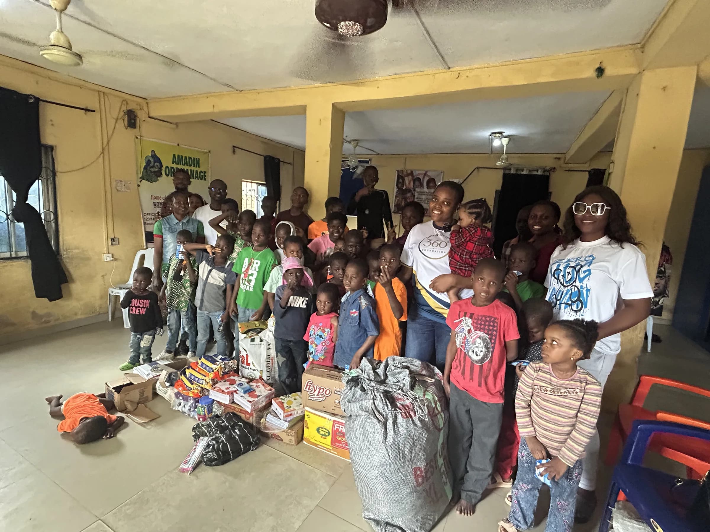Children and volunteers gathered with donated supplies at Amadin Orphanage, August 2026.